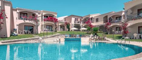 A resort with a central swimming pool, multiple balconies, and outdoor seating areas.