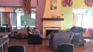 A cozy living room with a fireplace, comfortable seating, and a sewing machine.