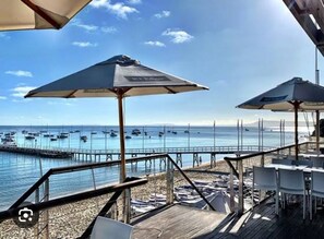 Un ristorante sul mare con posti a sedere all'aperto e vista sull'oceano.