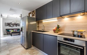 Enjoy cooking in this well-equipped kitchen with a stove, refrigerator, and sink.
