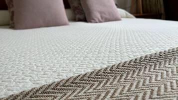 A bed with a patterned bedspread and two pillows.