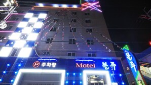 A building with a sign that reads "Motel" and a parking sign. - Blue Motel (Gwangju)