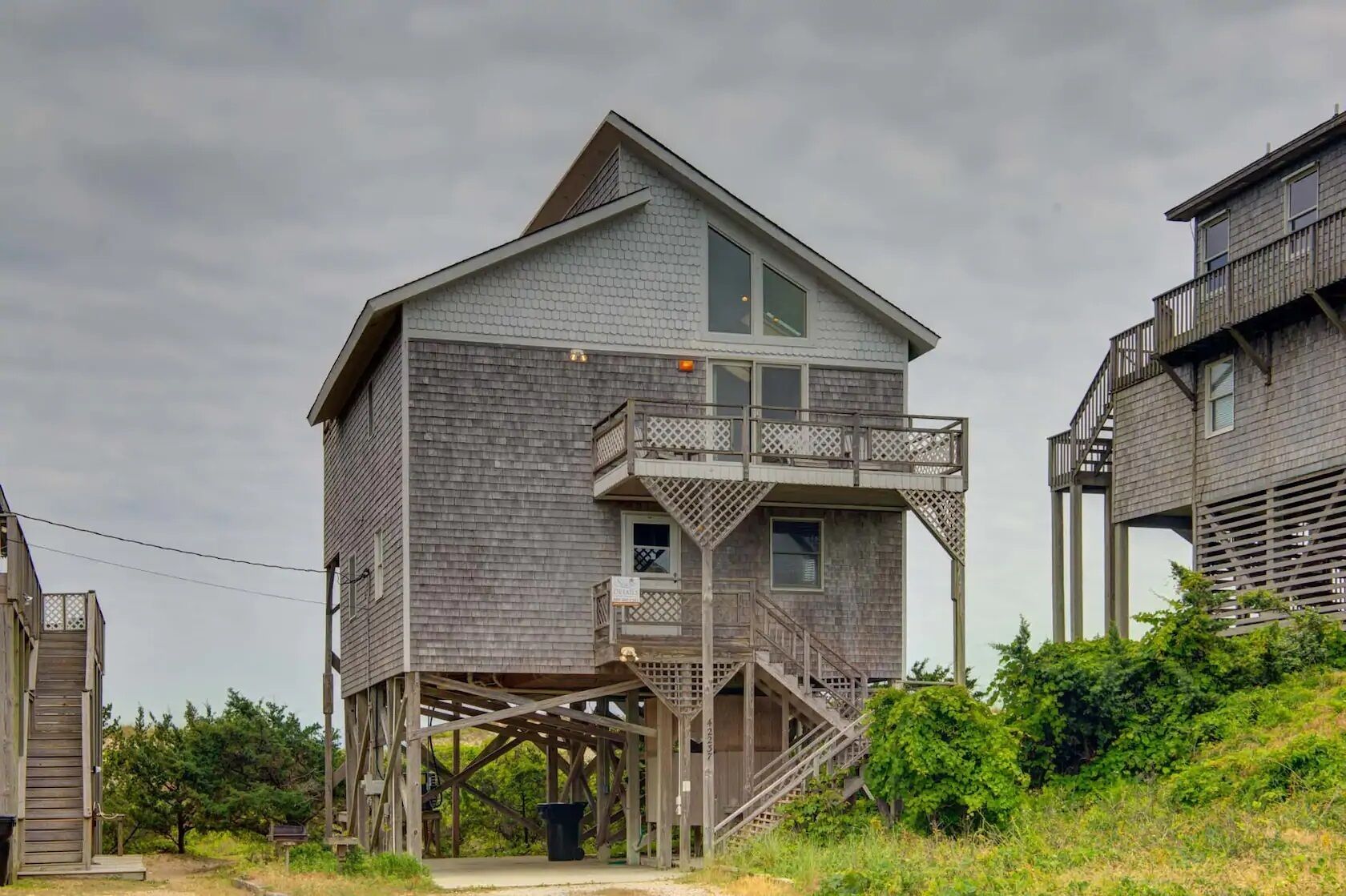 A two-story wooden house with a balcony and a wooden deck.