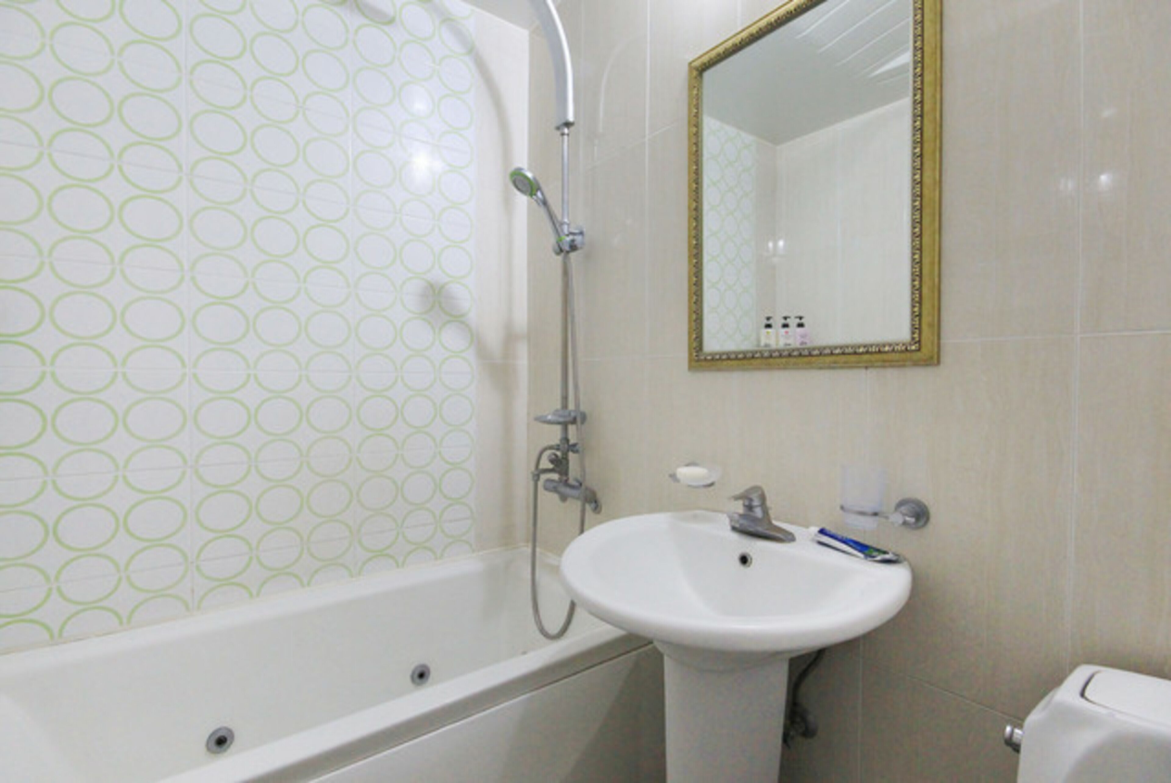 A bathroom with a bathtub, a sink, and a mirror.