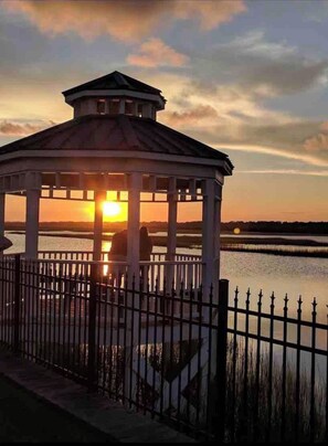 Situated beside a serene body of water, this gazebo offers a peaceful retreat.