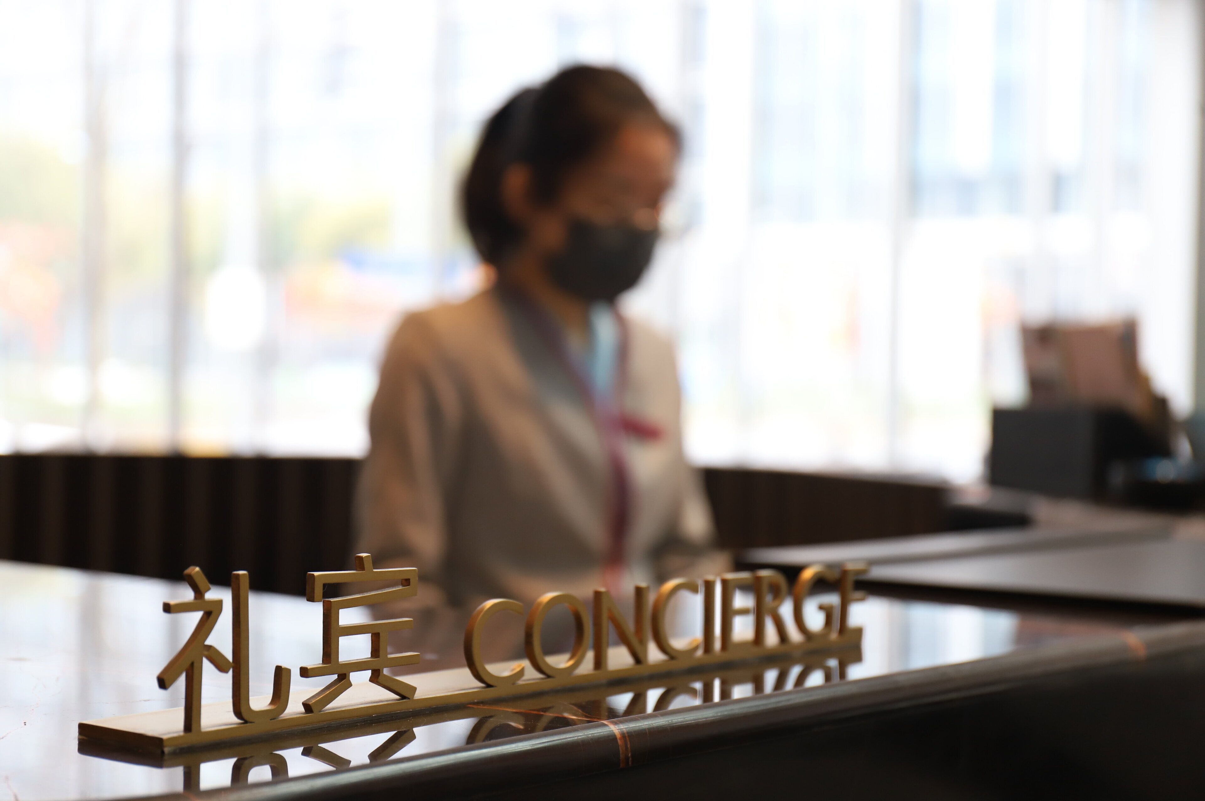 A reception desk with a sign that reads "Concierge" and "礼宾" in another language.