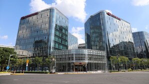 Moderni lasirakennus, jonka päällä on kyltti, jossa lukee ”Crown Plaza”.