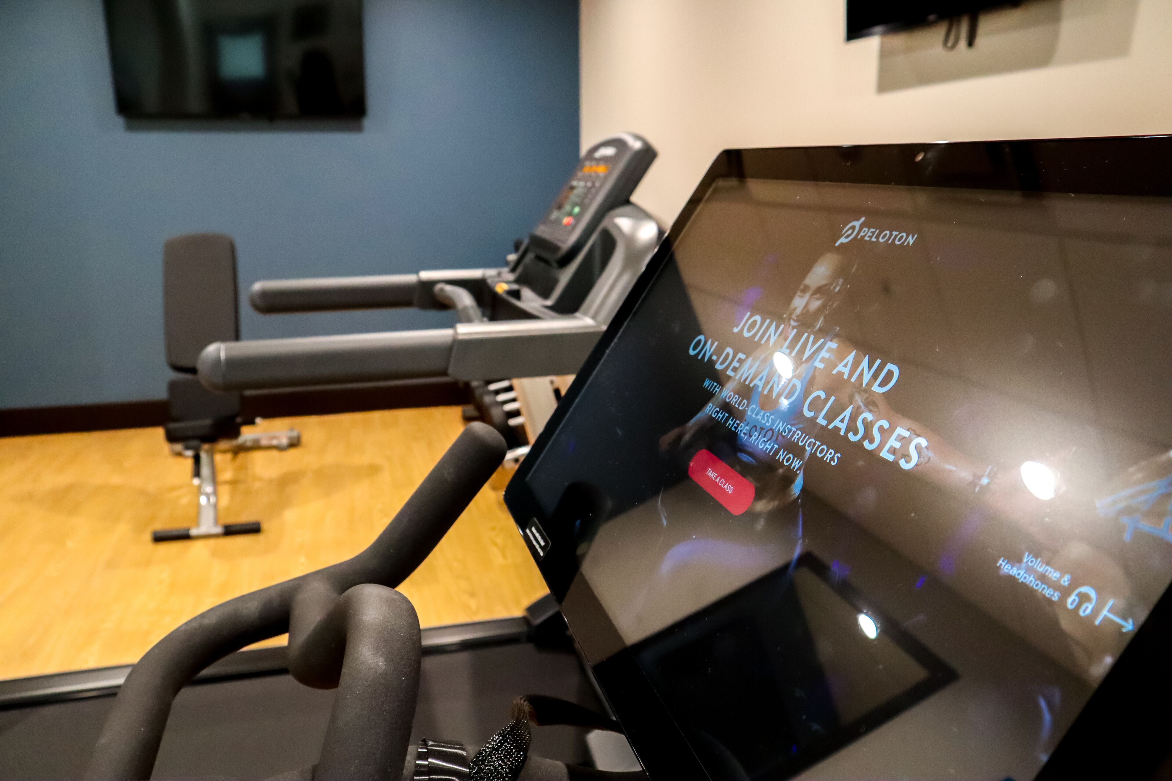 An exercise machine with a digital display advertising Peloton live and on-demand classes.