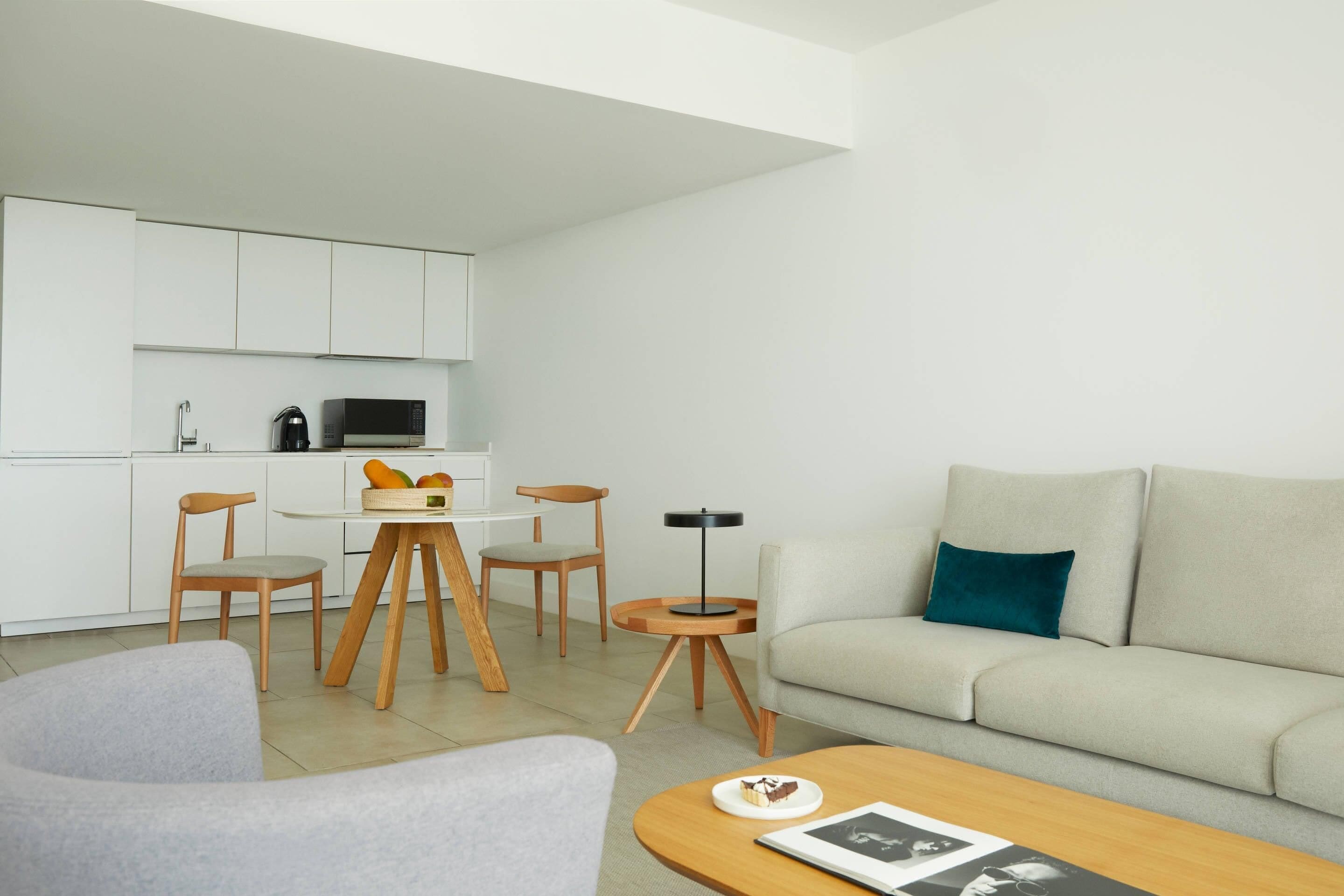 Una sala de estar moderna con un sofá, una mesa de centro y un comedor con sillas y una mesa.