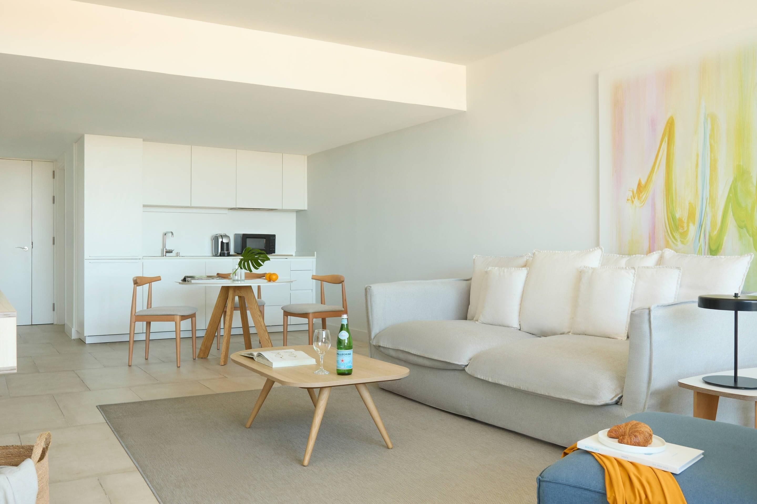 Un salon moderne comprenant un canapé, une table basse et un coin repas avec des chaises et une table.