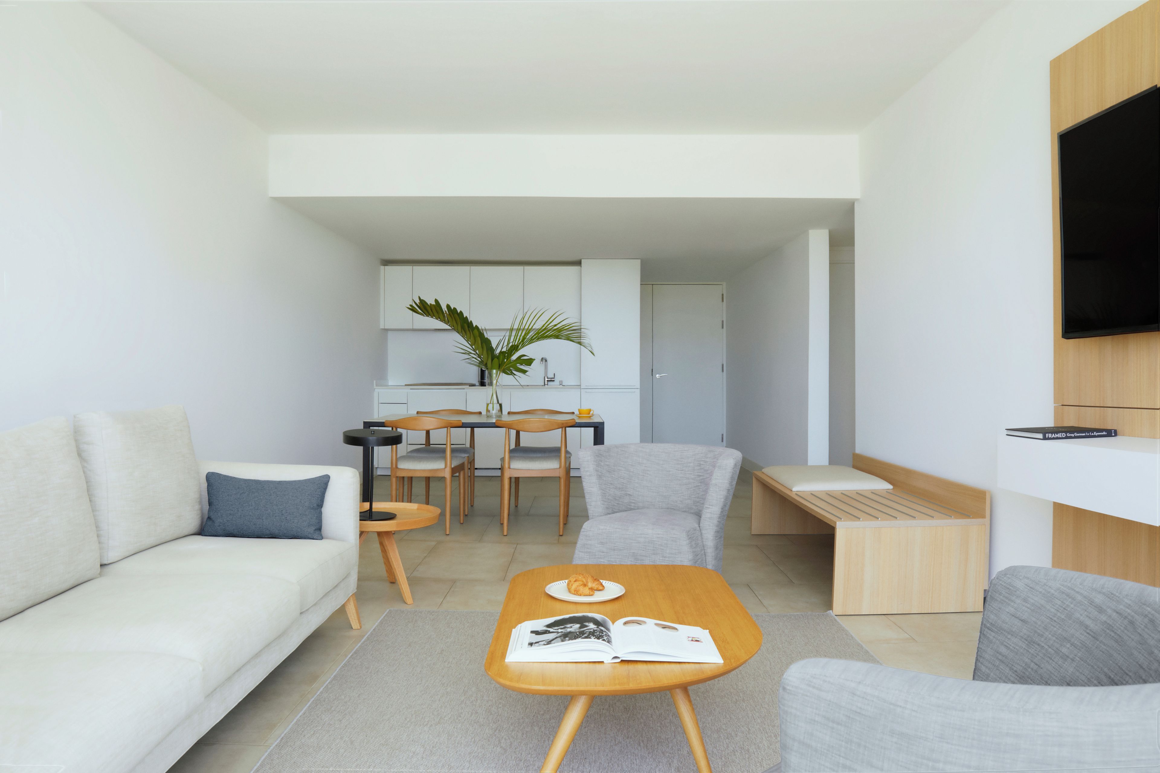 Una sala de estar moderna con un sofá, una mesa de centro y un comedor con sillas y una mesa.