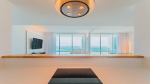 A modern hotel room with a large window, a flat-screen TV, and a black massage table. - Radisson Blu Aruba (Noord)