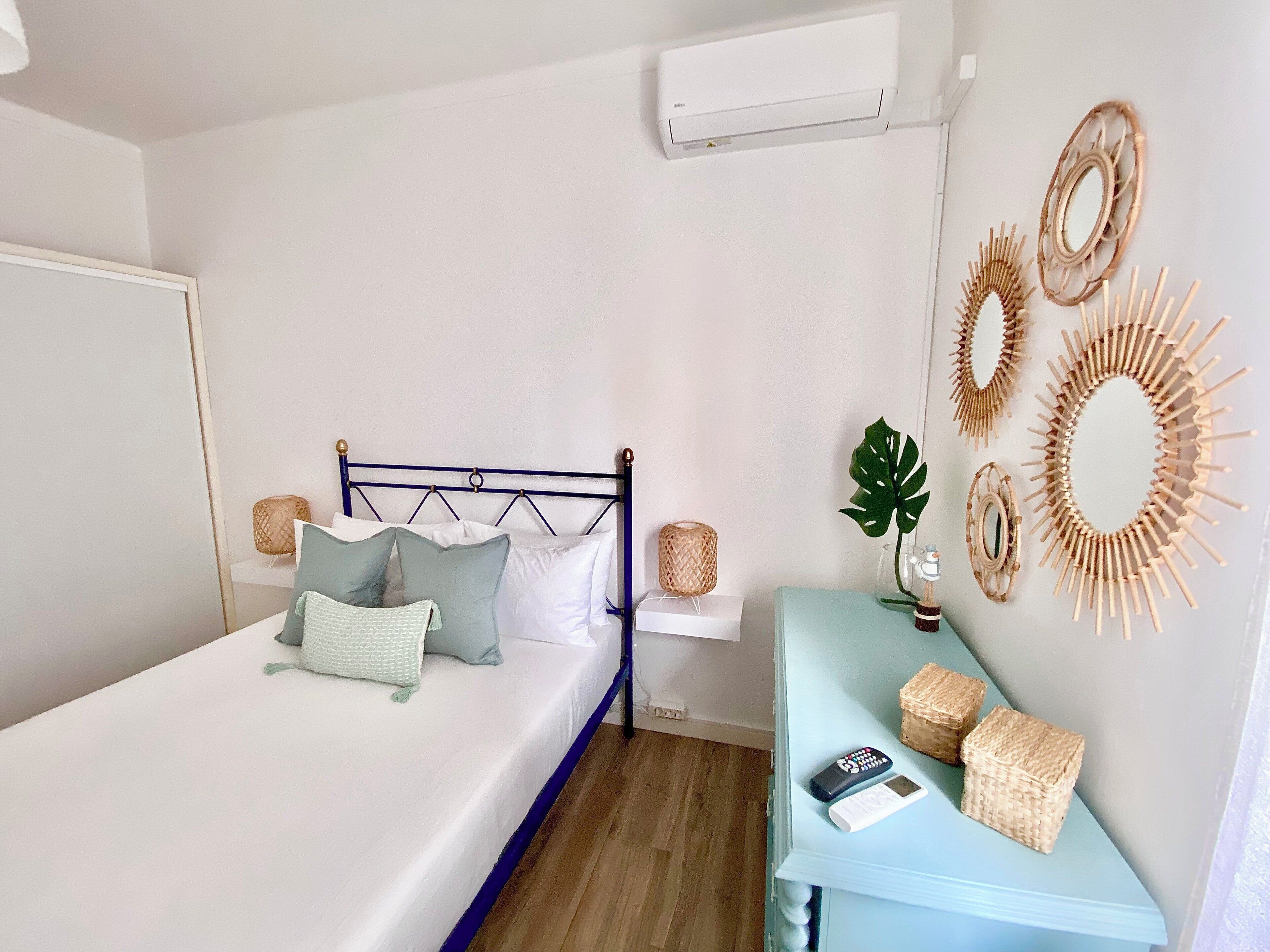 A neatly arranged bedroom with a bed, bedside table, and wall decorations.