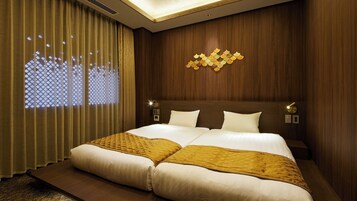 Habitación de hotel con una cama grande, paneles de madera, un adorno en la pared y una ventana con persiana estampada.