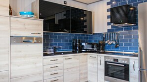 Una cocina moderna con horno Bosch, cafetera y lavamanos.