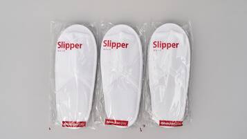 Three pairs of slippers in plastic packaging with the label "Slipper" and "Rakuten Stay".