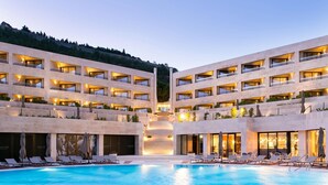 Et hotel med central pool, flere balkoner og bjergudsigt.
