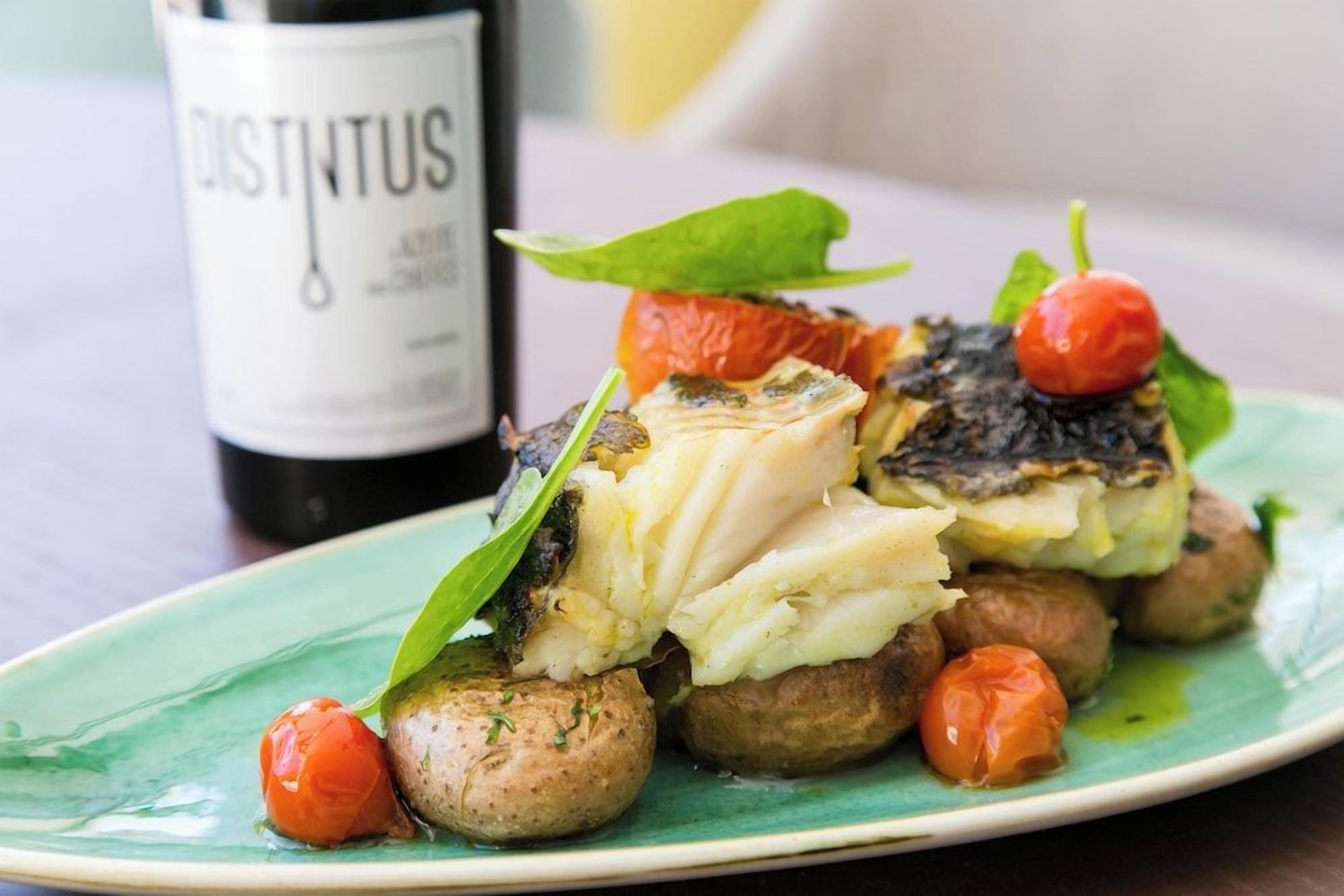 A plate of food with a bottle labeled 'DISTINTUS' in the background.