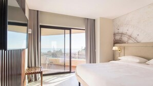 A modern hotel room with a large bed, a view through a sliding glass door, and a balcony. - Four Points By Sheraton Sesimbra (Sesimbra)