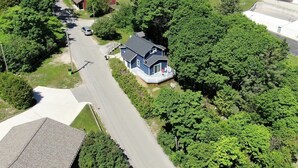 Ein Wohngebiet mit einem zweistöckigen Haus und einer Veranda mit Sitzgelegenheiten.