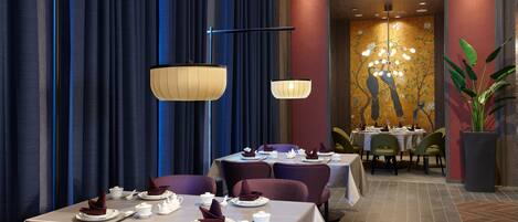 A restaurant with tables set for dining, featuring a modern chandelier and a mural on the wall.