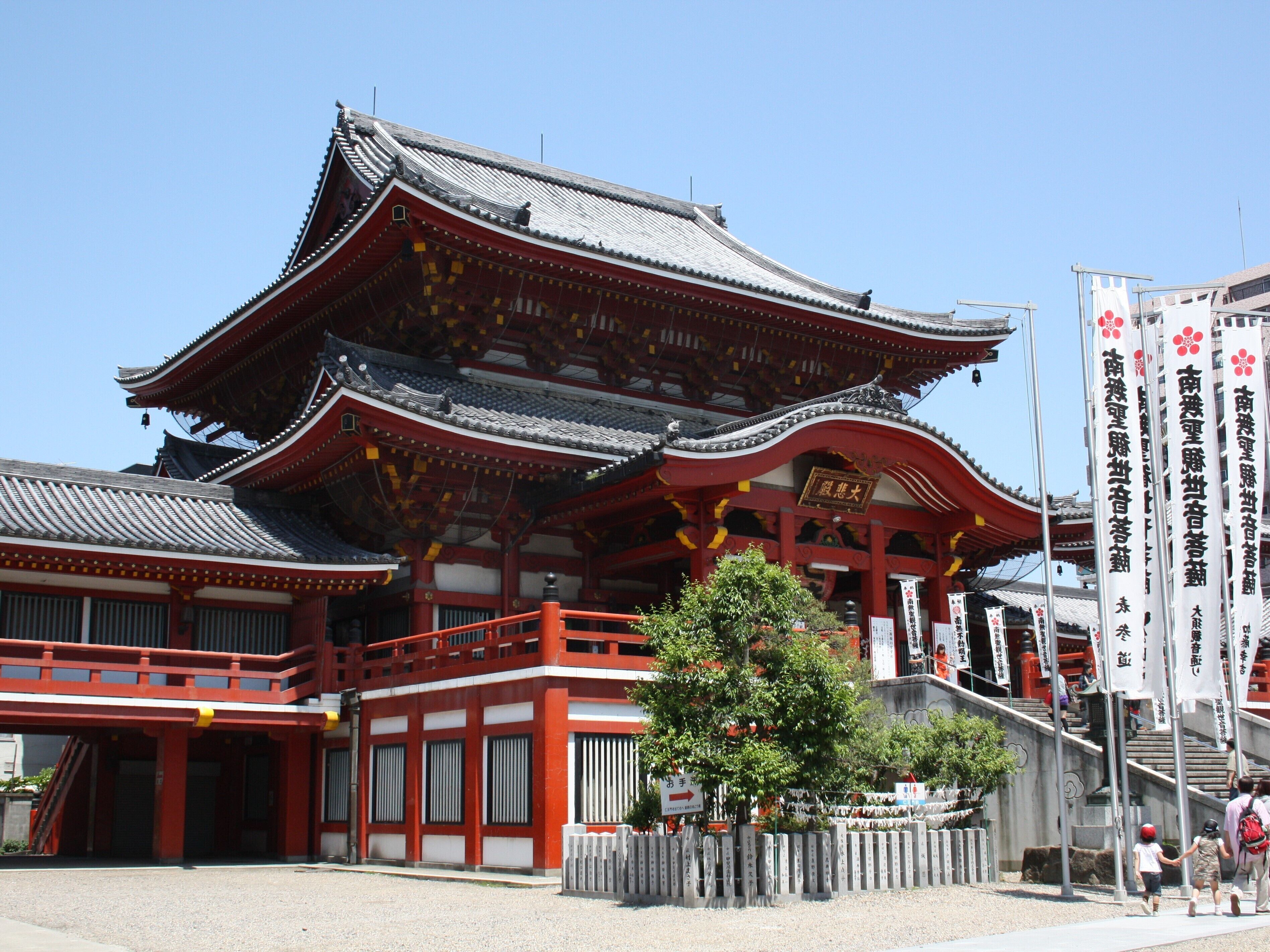 Un edificio japonés tradicional con una decoración en rojo y blanco, que presenta un tejado curvo y varios niveles.