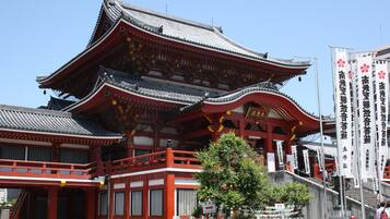 Un edificio japonés tradicional con una decoración en rojo y blanco, que presenta un tejado curvo y varios niveles.
