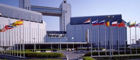 A modern building with a large entrance and multiple flags.