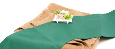 A folded green fabric with a small white box containing flowers on top.