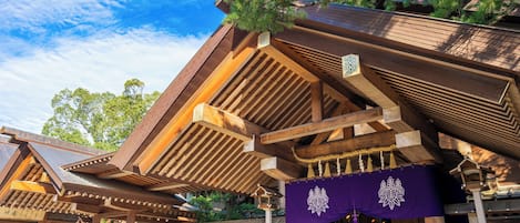 A traditional Japanese building with wooden beams and a purple hanging banner.