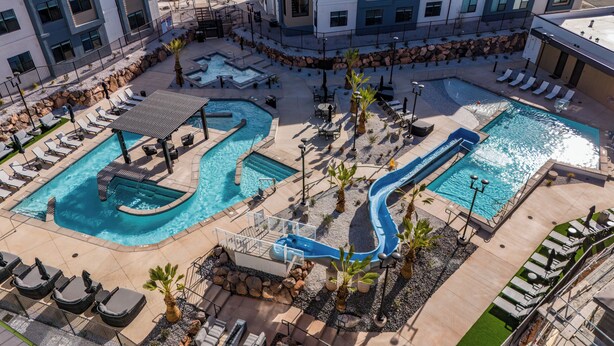 A multi-level pool area with various water features, including a slide, surrounded by lounge chairs and seating areas. - B6, Hillside Hideaway, Indoor and Outdoor Fireplace, Community Amenities, Near Sand Hollow (Hurricane)