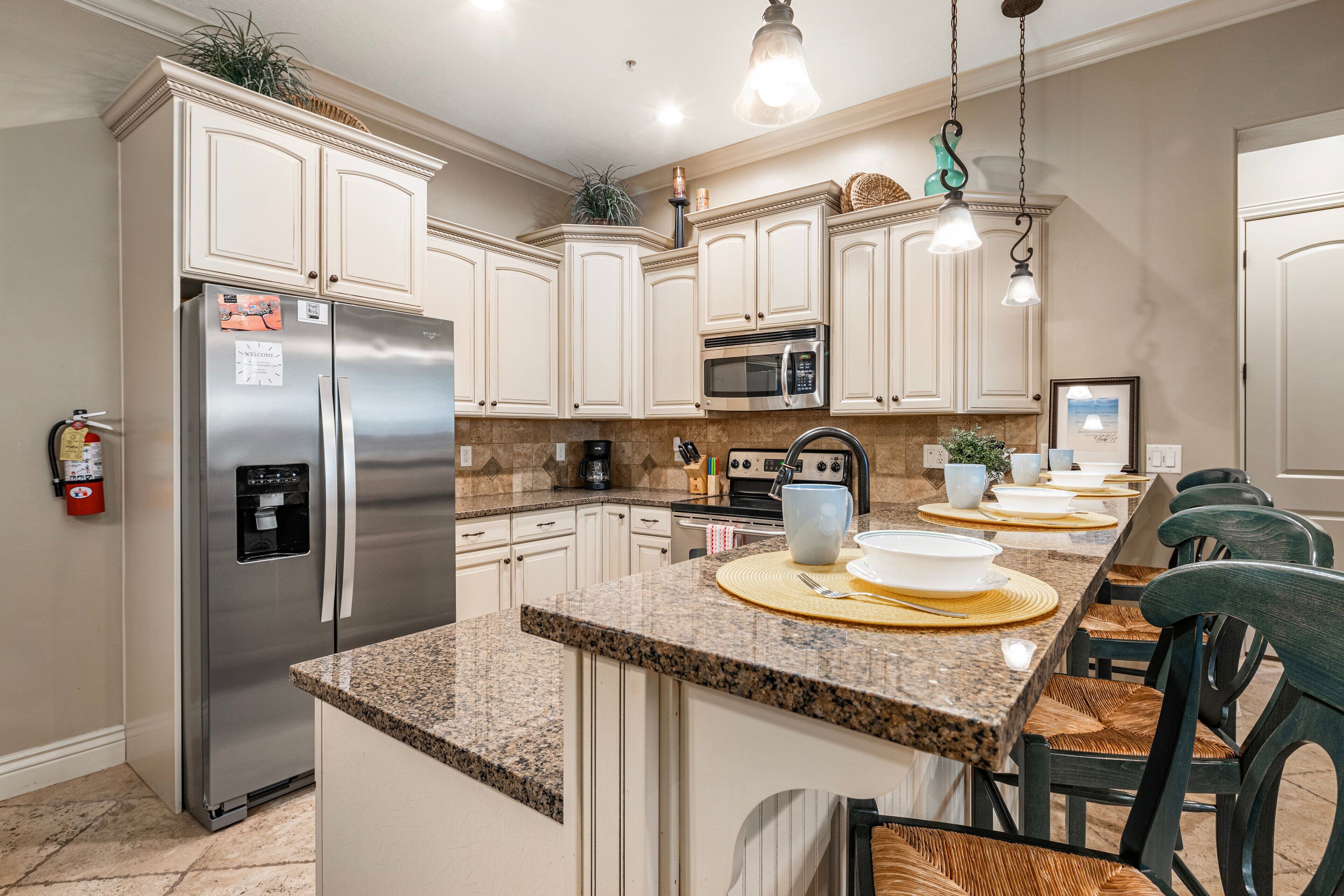 A modern kitchen with stainless steel appliances, granite countertops, and a breakfast bar with seating.