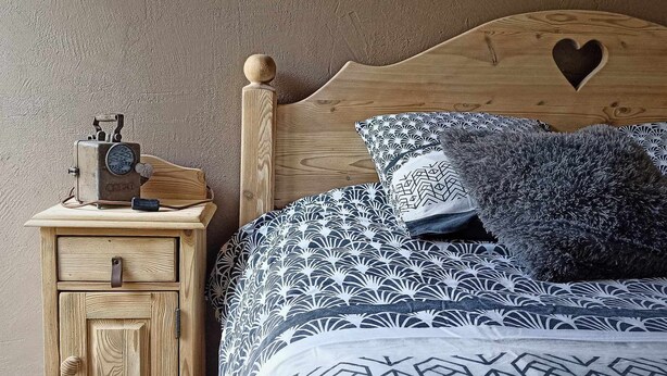 A wooden bed with a heart-shaped headboard, a nightstand with a vintage radio, and patterned bedding. - ❤LA GRANGE SAVOYARDE⭐⭐⭐Lac 1KM-💦Pool-Charm (Lathuile)