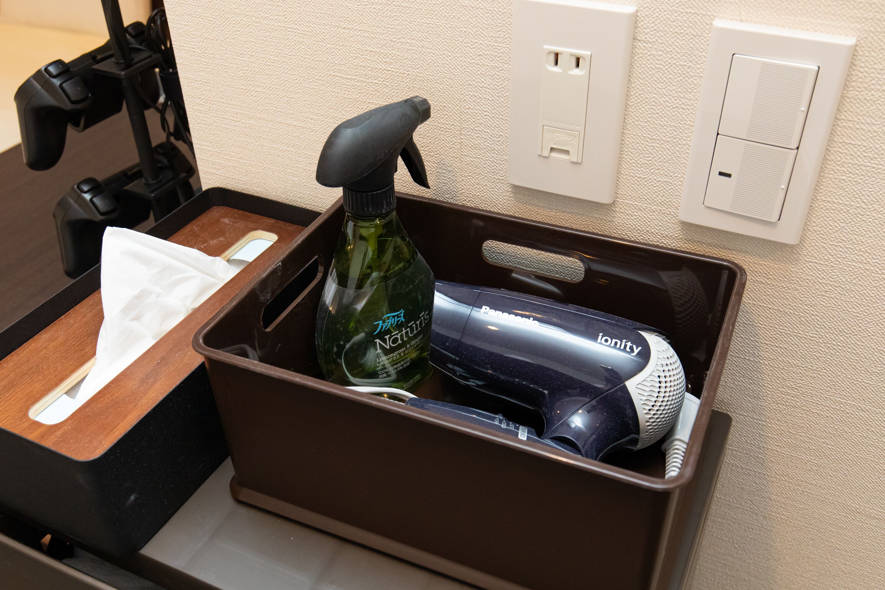 A bathroom with a wooden tray, a spray bottle, and a hairdryer.