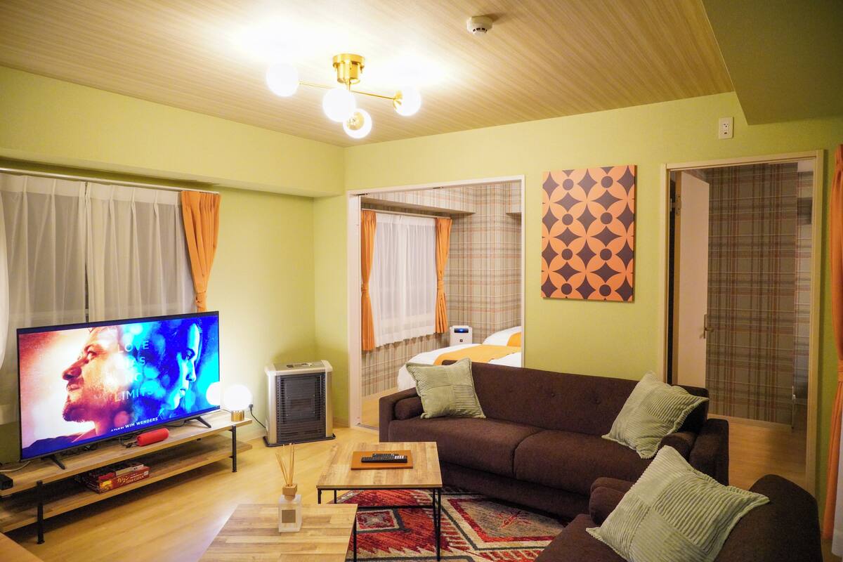A living room with a television, sofa, and a small table.