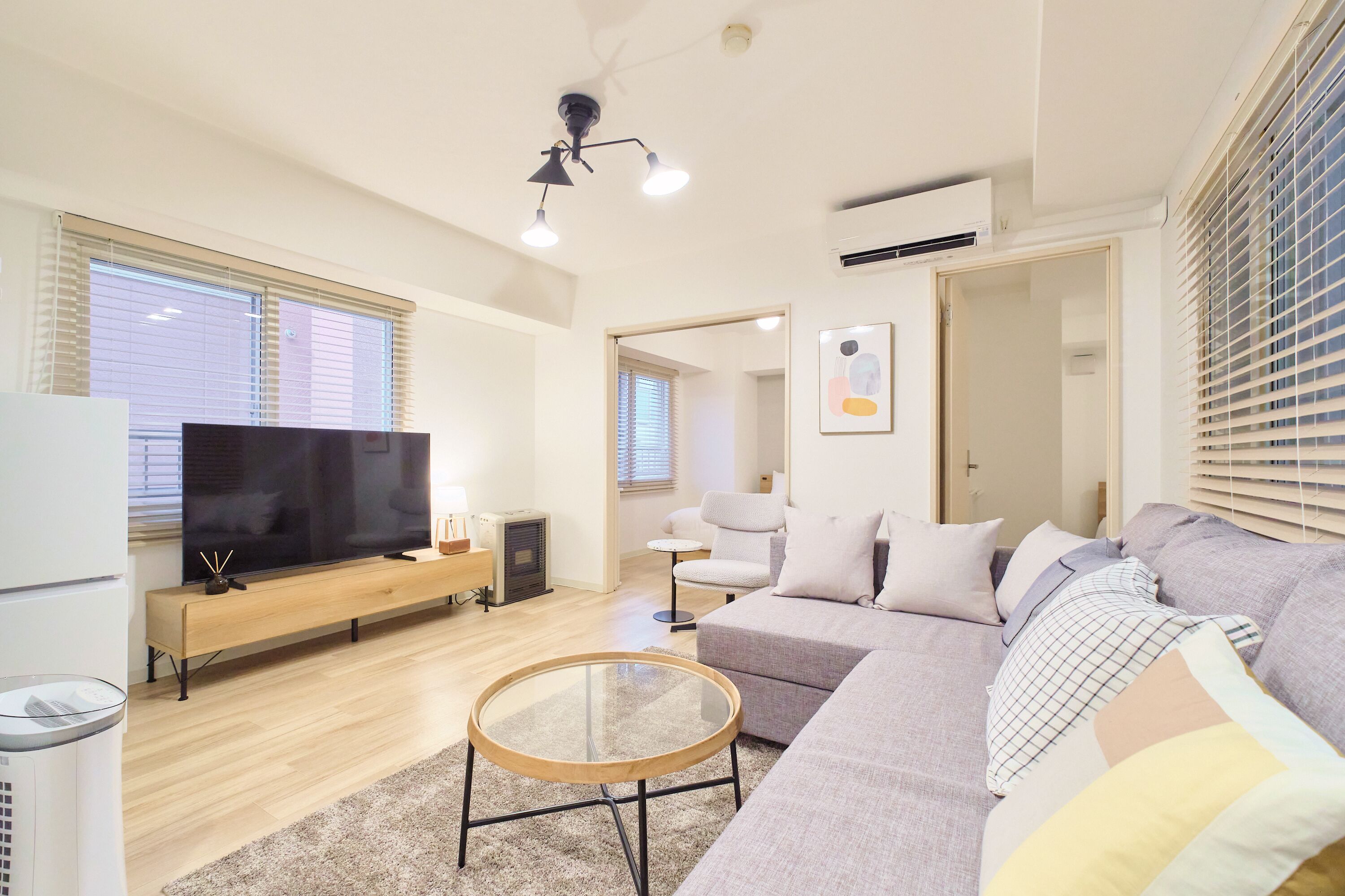 A modern living room with a flat-screen TV, a sofa, a coffee table, and a fireplace.