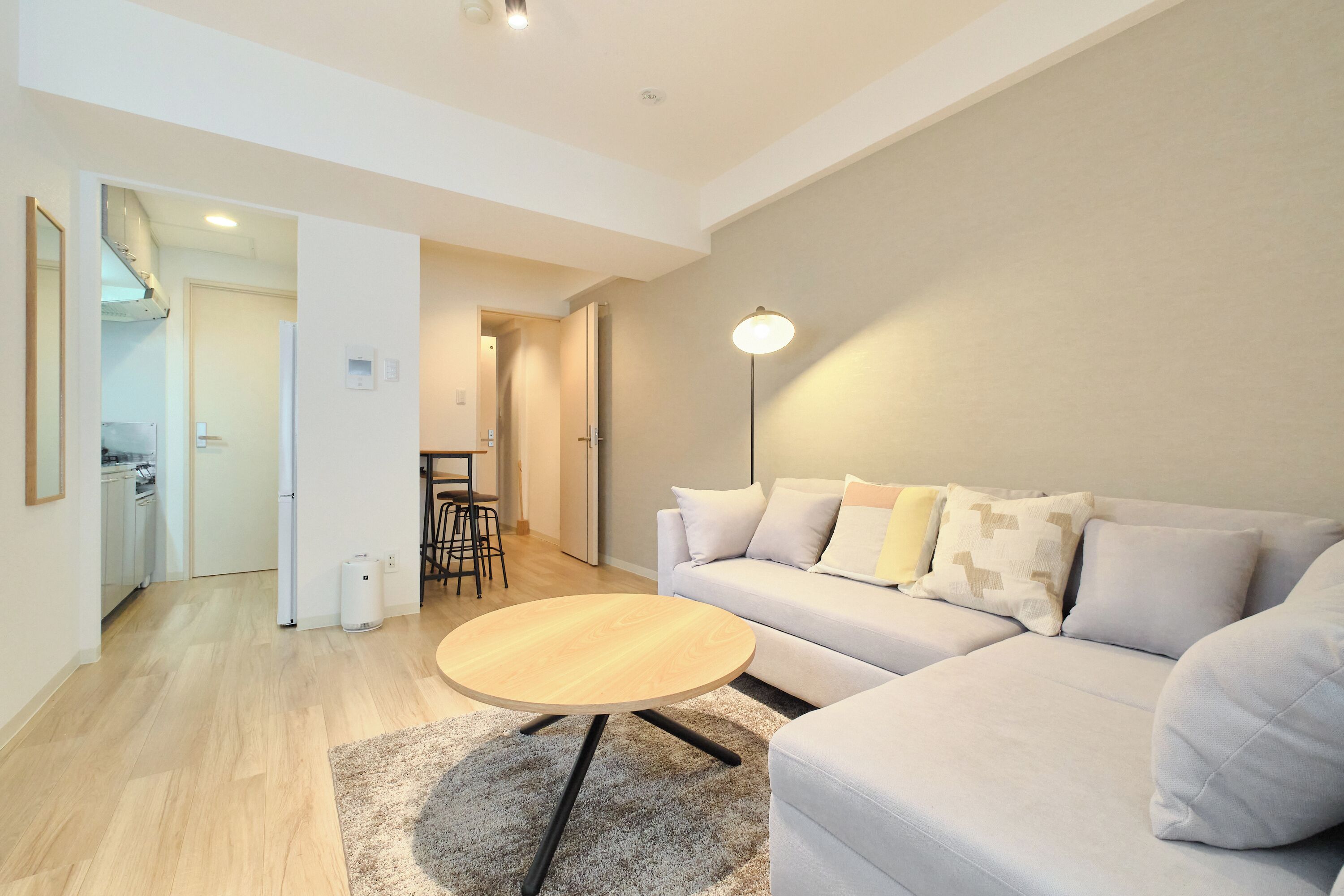 A modern living room with a sofa, a round coffee table, and a floor lamp.