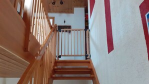 A wooden staircase with a handrail leading to a landing. - Ferienwohnung Teschow (Teterow)