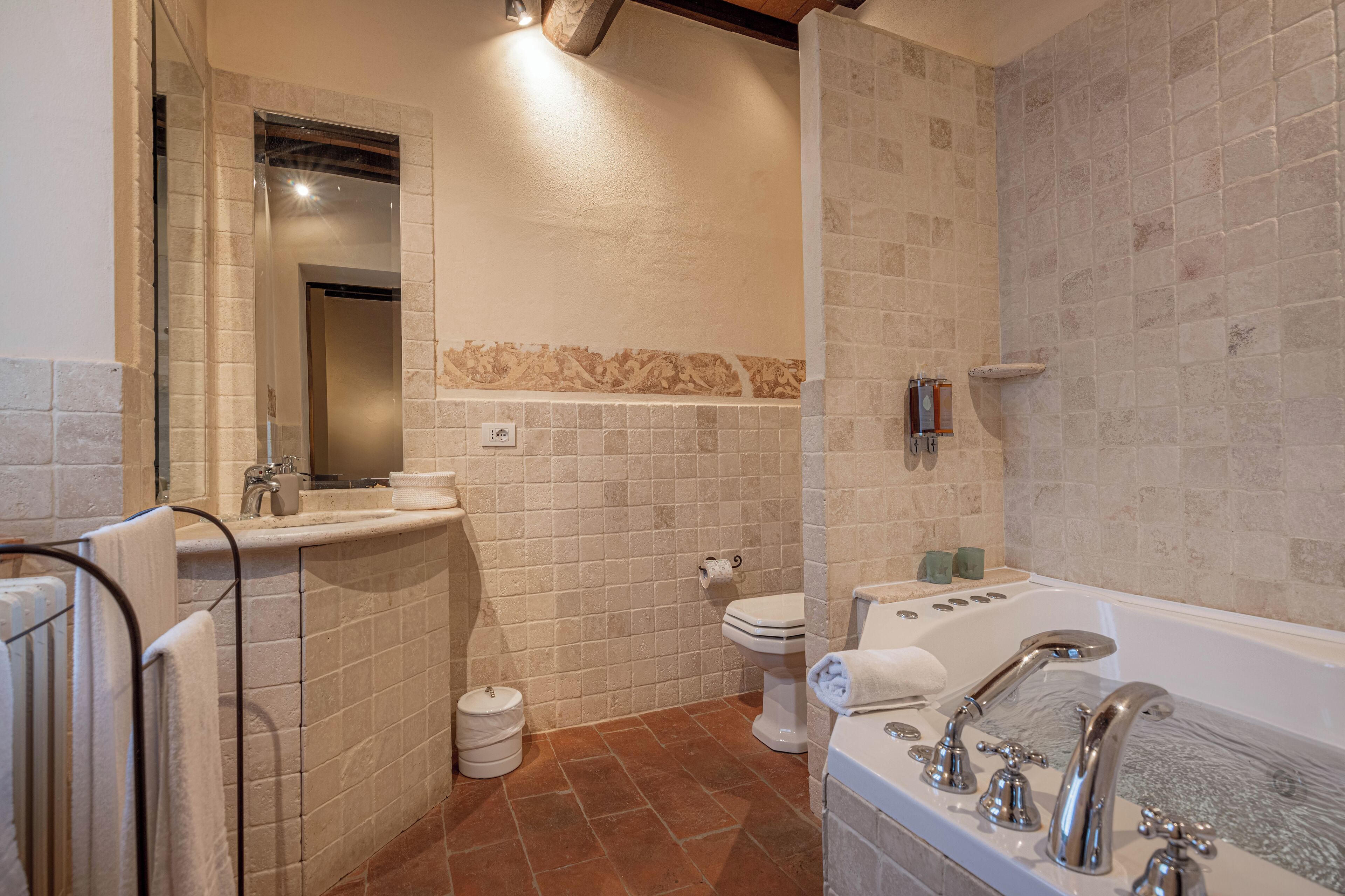 Een moderne badkamer met een bad, toilet en wastafel.