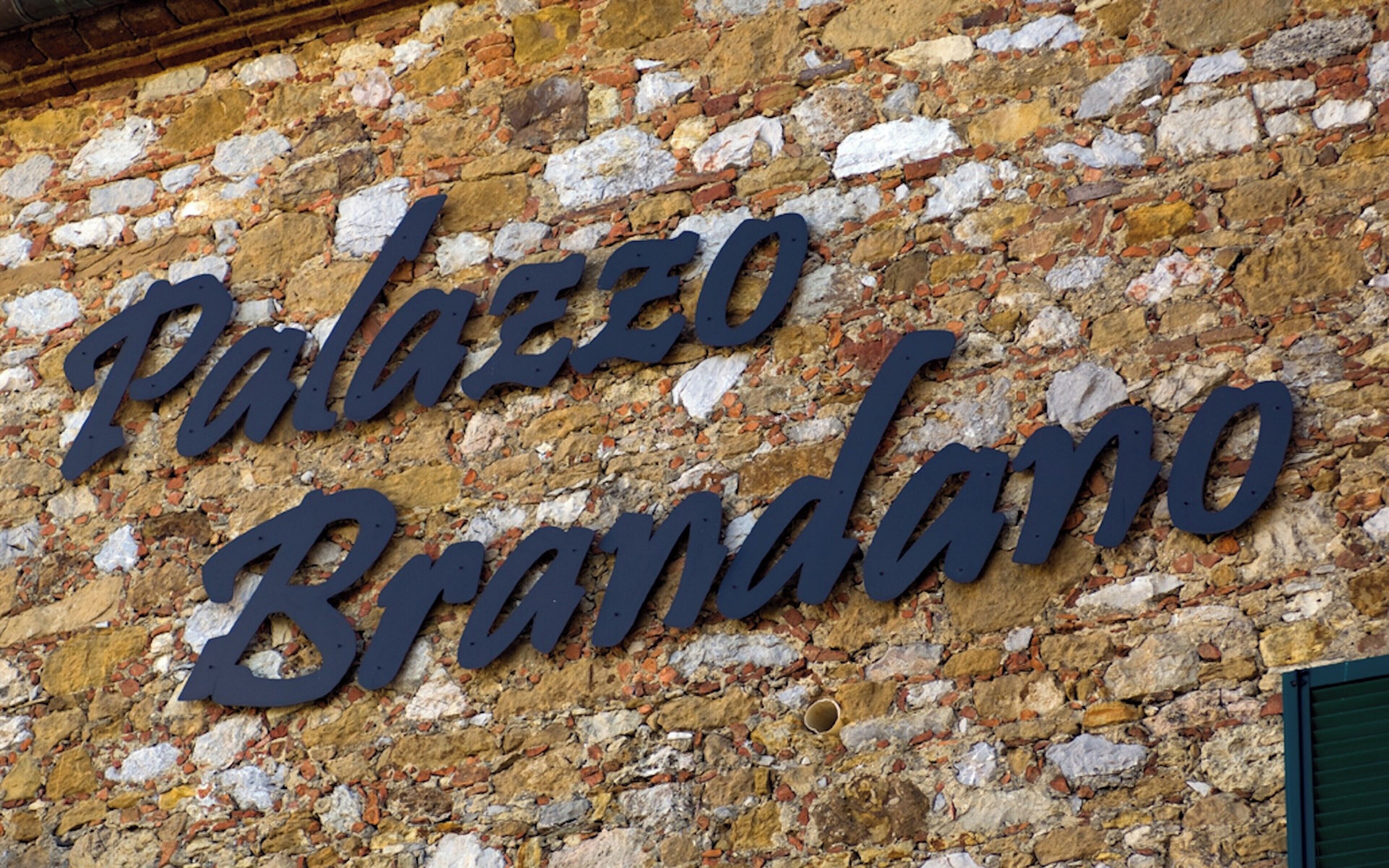 Eine Steinmauer mit der Inschrift "Palazzo Brandano".