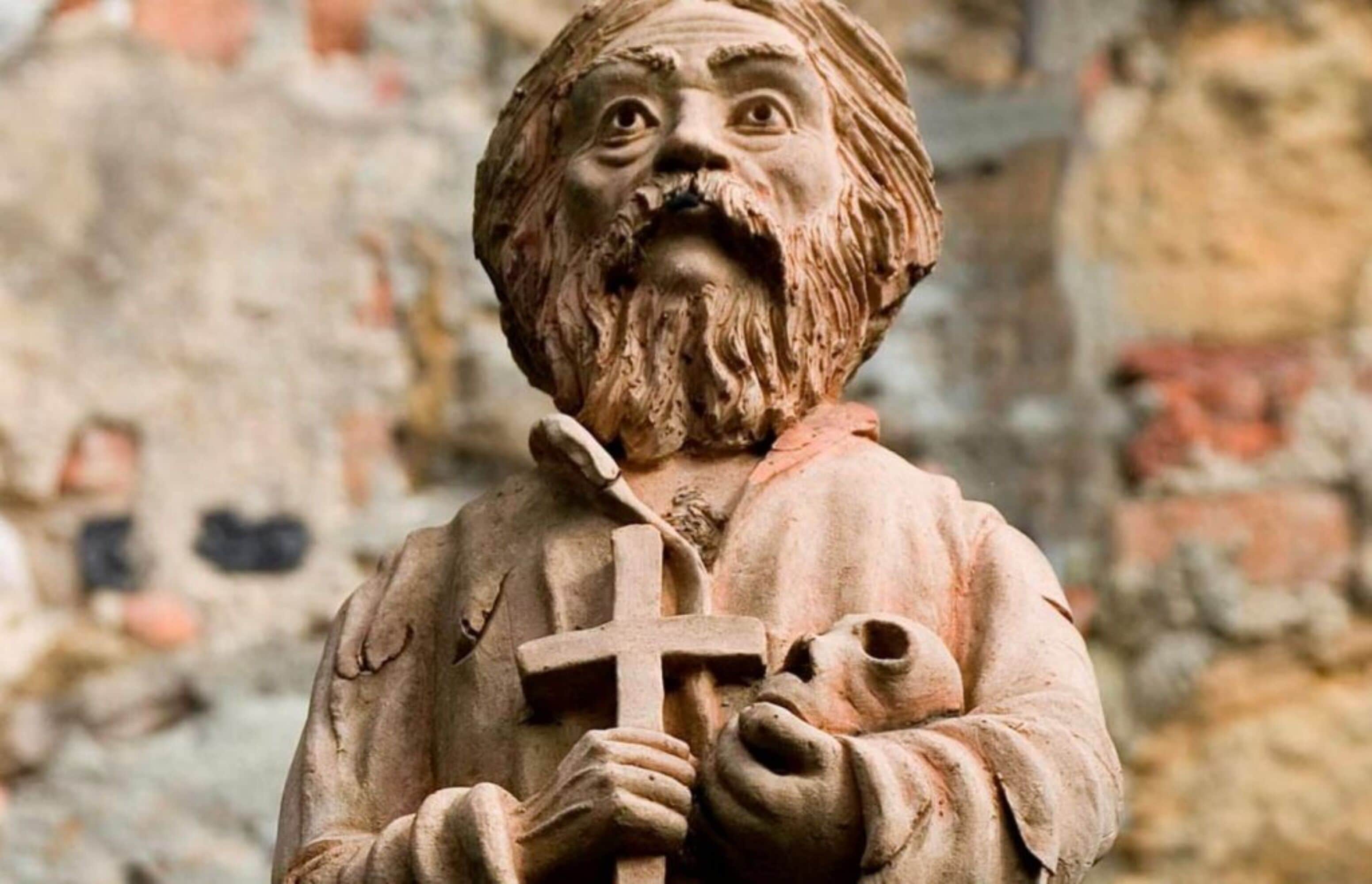 A statue of a bearded man holding a cross and a child.