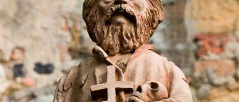 A statue of a bearded man holding a cross and a child.