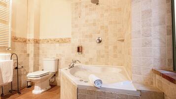 A bathroom with a bathtub, toilet, and a towel rack.