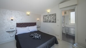 A bedroom with a large bed, bedside tables, a dresser, and a mirror. - Palazzo Rocco - Penthouse White Moon in Love - 2 rooms - 2 bath - 6 pax max (Praiano)