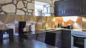 Eine moderne Küche mit einer Steinwand, einer Kaffeemaschine, einem Toaster und einem Einbauofen.