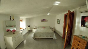Una camera da letto con un letto, una cassettiera, comodini e uno specchio.
