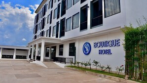A modern hotel building with a prominent sign reading "BOUTIQUE HOTEL".