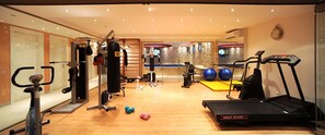 A gym with cardio equipment, weights, and exercise balls.