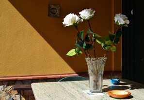 A table with a vase of white roses, a blue bowl, and a ceramic plate. - B b S Elia Villa Surrounded by Greenery Inside the Historic Dubini Park (San Cataldo)
