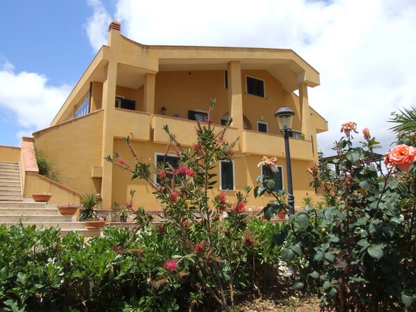 A multi-story building with balconies and a garden in the foreground. - B b S Elia Villa Surrounded by Greenery Inside the Historic Dubini Park (San Cataldo)